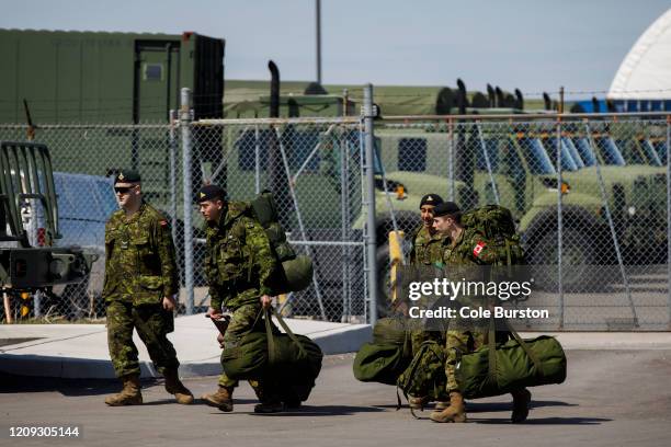 Members of the Canadian Forces head to their vehicles at Denison Armory to convoy to CFB Borden amid the spread of the coronavirus disease on April...