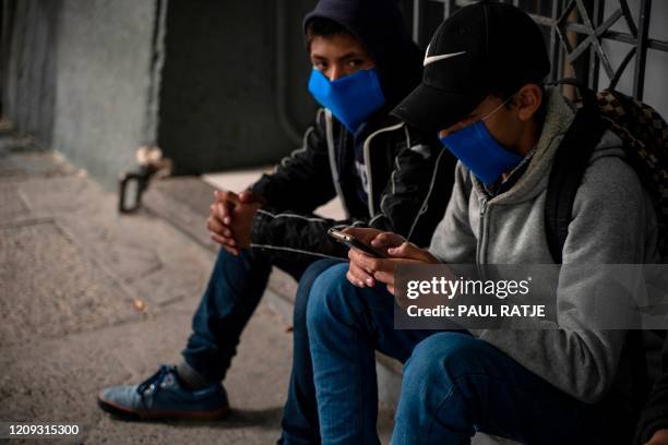 Migrants part of Migrant Protection Protocols, or the Remain in Mexico wear masks while waiting to enter the the Paso del Norte International Bridge...