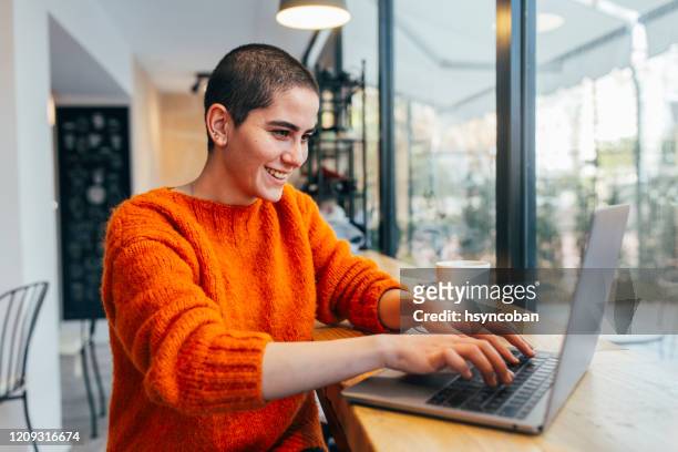 woman working on laptop in a cafe - west asia stock pictures, royalty-free photos & images