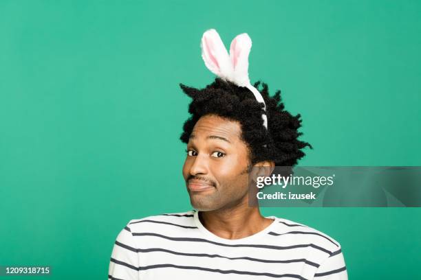 spring portrait of cute young man with rabbit ears headband - rabbit costume stock pictures, royalty-free photos & images