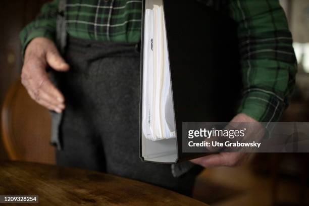 In this illustration an old man holds a file folder under his arm. HEIDELBERG, GERMANY on February 14, 2020 in Heidelberg, Germany.