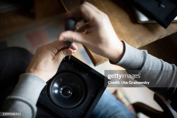 In this photo illustration a man is repairing a loudspeaker.. HEIDELBERG, GERMANY on February 14, 2020 in Heidelberg, Germany.