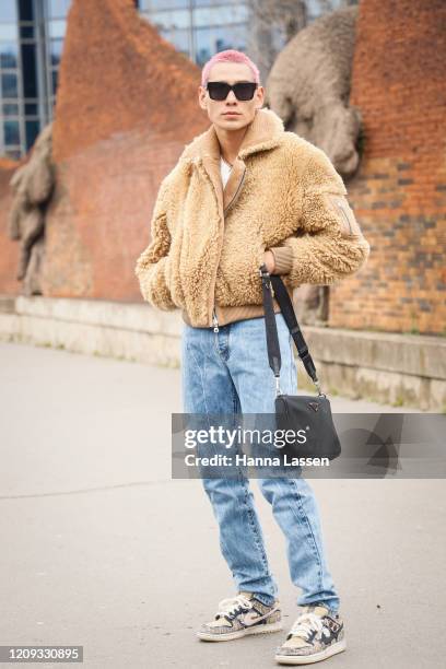 Evan Mock wearing fleece jacket, jeans, Nike sneakers, sunglasses and Prada black bag outside the Balmain show during the Paris Fashion Week...