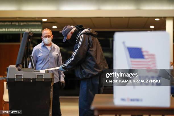 Man casts his ballot in a Democratic presidential primary election at the Journey Church in Kenosha, Wisconsin, on April 7, 2020. - The Wisconsin...