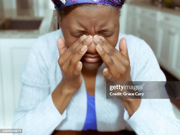woman with sinus pain presses nose - sinus stock-fotos und bilder