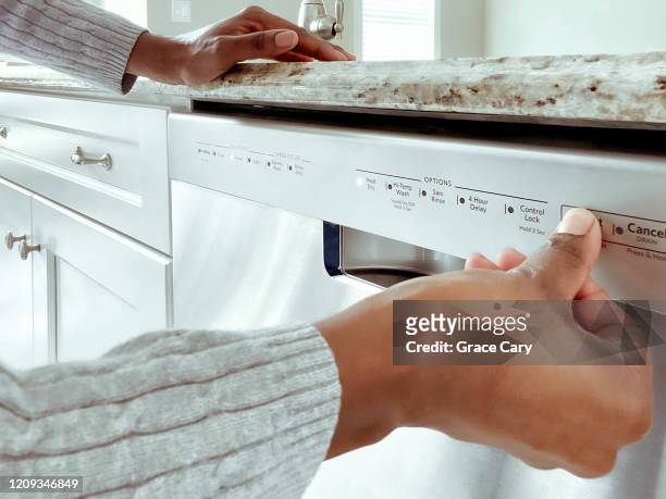 woman starts dishwasher - dishwasher stock pictures, royalty-free photos & images