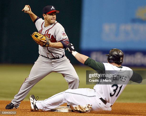 Atlanta second baseman Marcus Giles turns the double play as Tampa Bay's Jonny Gomes tries to break it up in Friday night's action at Tropicana Field...