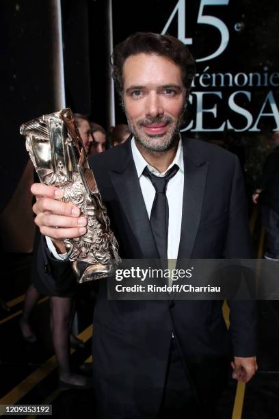 Nicolas Bedos poses with the “Best Original Screenplay” award for the movie 'La Belle Époque' during the Cesar Film Awards 2020 Ceremony at Salle...