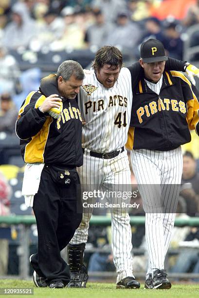 Pittsburgh Pirates Ryan Doumit is helped off the field by trainer Brad Henderson and Manager Jim Tracy after pulling a hamstring running to first...