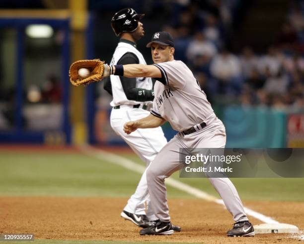 New York Yankee infielder Tino Martinez takes the pickoff throw from the pitcher as Tampa Bay Devil Rays outfielder Carl Crawford hurries back to...