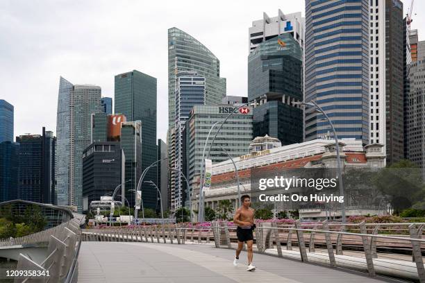 Man jogs on the Esplanade Bridge at the Marina Bay area on the day a 'circuit breaker' takes effect on April 7, 2020 in Singapore. The Singapore...