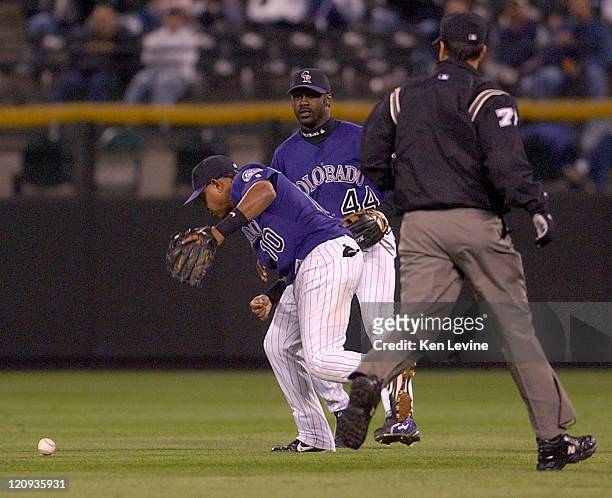 Colorado Rockies second baseman Ronnie Belliard looks down at the ball that fell between him and Preston Wilson on a hit by the Houston Astros' Lance...