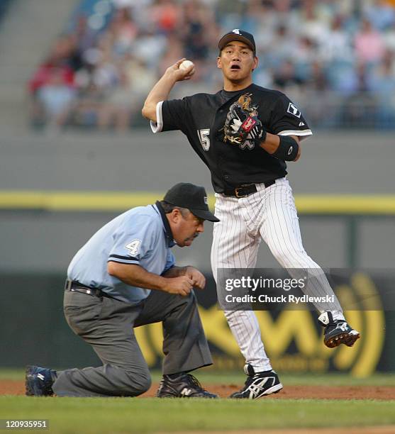 Chicago White Sox 2nd baseman, Tadahito Iguchi, makes a nice play while umpire, Tim Tschida ducks out of the way during the game against the Tampa...