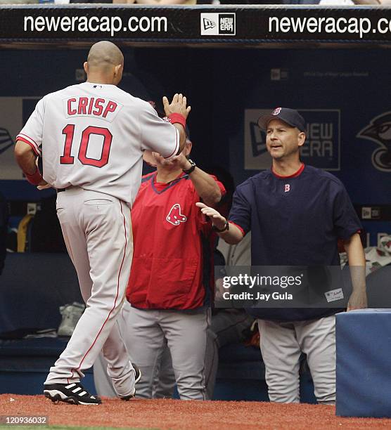 Boston's Coco Crisp is congratulated by manager Terry Francona after scoring the Red Sox first run during the Boston Red Sox vs Toronto Blue Jays on...