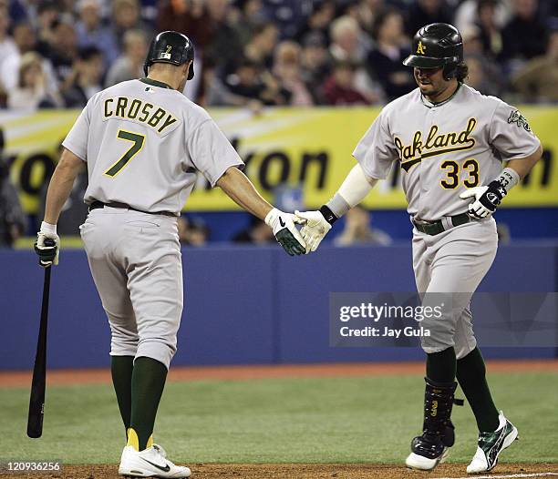 Oakland A's Nick Swisher is congratulated by Bobby Crosby after hitting his 1st of 2 HR's today vs the Toronto Blue Jays in MLB action at Rogers...