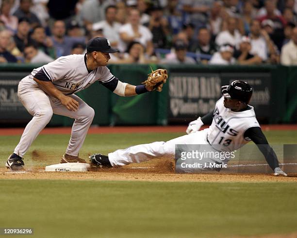 Tampa Bay's Carl Crawford slides safely into third with a triple as New York's Alex Rodriguez prepares for the tag in Wednesday night's game at...