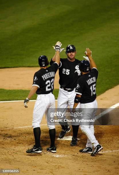 Chicago White Sox' DH/1B, Jim Thome,is greeted at home plate by teammates, Scott Podsednik and Tadahito Iguchi, who scored ahead of his 3-run homer...