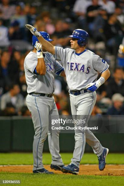 Texas Rangers' Shortstop, Michael Young, gets a high-five from teammate, Gerald Laird, after hitting a 3-run homer during the game against the...