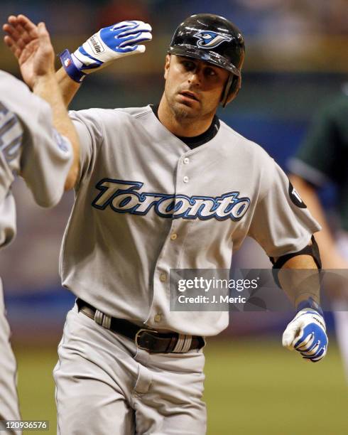 Toronto center fielder Reed Johnson gets a high five from third base coach Brian Butterfield after his first inning home run against Tampa Bay at...