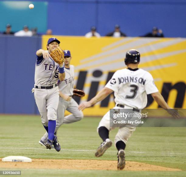 Texas Rangers 2B Ian Kinsler throws to 1st base to complete a double play over a sliding Reed Johnson of the Toronto Blue Jays in MLB action at...