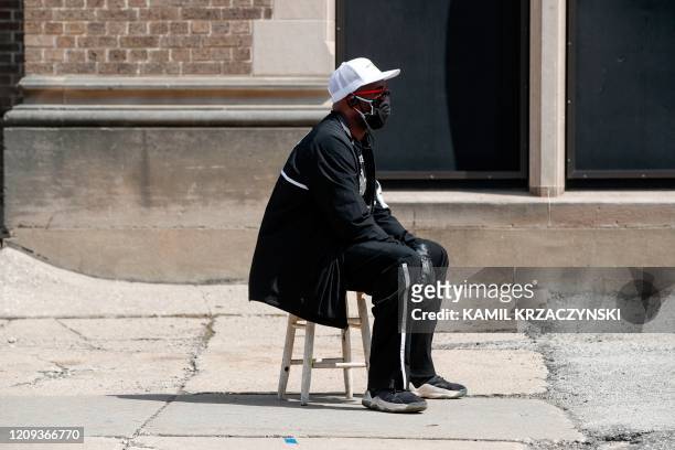 Man waits in long line to vote in a presidential primary election outside the Riverside High School in Milwaukee, Wisconsin, on April 7, 2020. -...