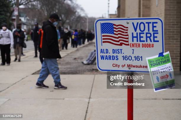 Flyer displayed on a "Vote Here" sign informs voters about social distancing outside a polling station in Milwaukee, Wisconsin, U.S., on Tuesday,...