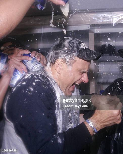 New York Yankees manager Joe Torre is doused in champagne as his team celebrates in their clubhouse after clinching their 9th consecutive American...