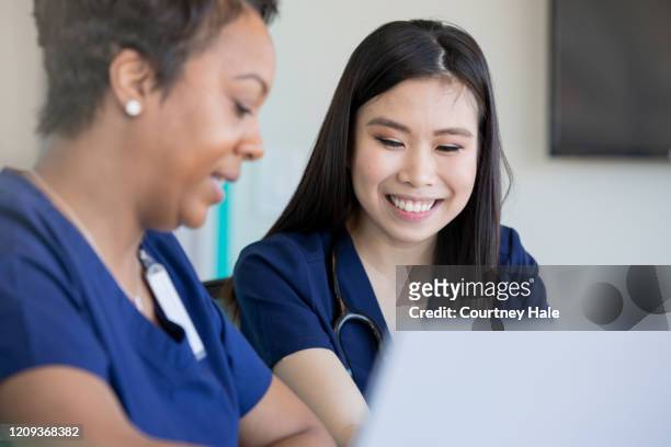zwei medizinische fachfrauen, die an einem laptop arbeiten - the resident screening stock-fotos und bilder
