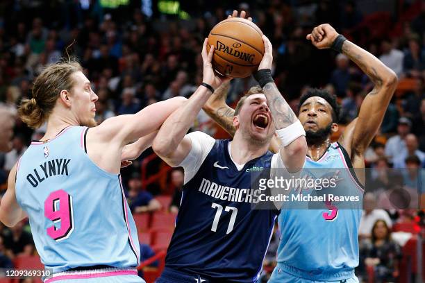 Luka Doncic of the Dallas Mavericks drives to the basket against Kelly Olynyk and Derrick Jones Jr. #5 of the Miami Heat during the first half at...