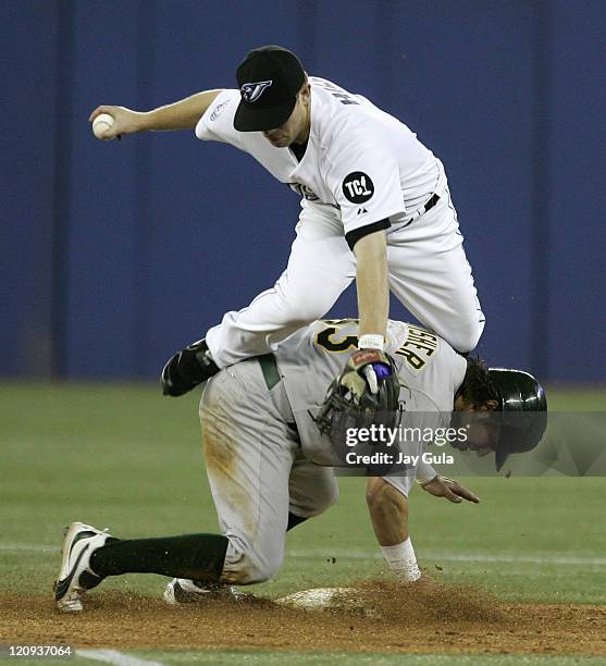 Toronto Blue Jays 2b Aaron Hill goes over the back of Oakland A's Nick Swisher after forcing him out at second base in MLB action at Rogers Centre in...