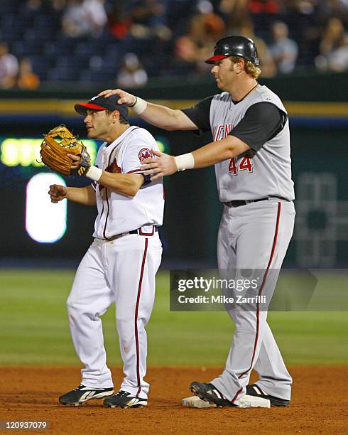 Atlanta Braves 2B Marcus Giles is distracted by Cincinnati Reds LF Adam Dunn while the cutoff throw is coming in during the game at Turner Field in...