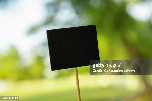 wooden stick with blackboard against green nature - wooden stick stock pictures, royalty-free photos & images