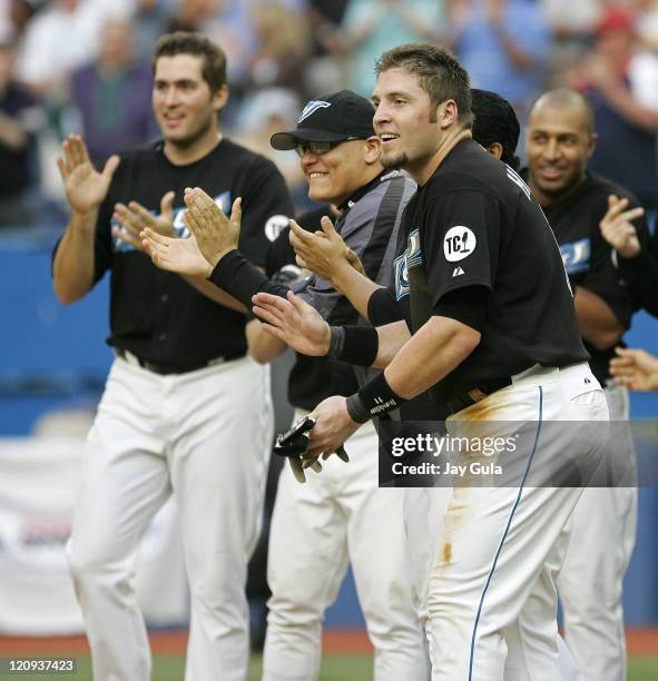 Toronto Blue Jays Troy Glaus, Gustavo Chacin, Eric Hinske, and Vernon Wells await Shea Hillenbrand's arrival at home plate with the winning run after...