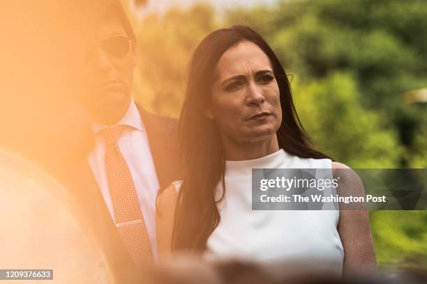 White House Press Secretary Stephanie Grisham listens as President Donald J. Trump stops to talk to reporters and members of the media about former...