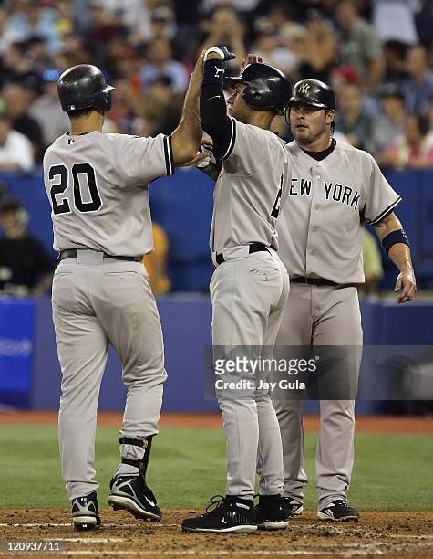 The New York Yankees' Jason Giambi and Derek Jeter congtaulate Jorge Posada after his 3 run HR in the 3rd inning against the Toronto Blue Jays at...