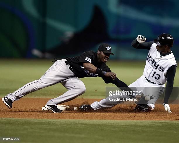 Tampa Bay Devil Rays outfielder Carl Crawford slides safely into second base with a steal as Toronto Blue Jays second baseman Orlando Hudson tries to...