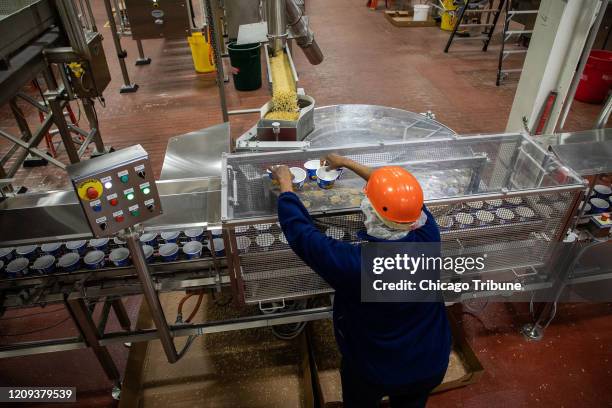 Phillis Knight works on the production line of Easy Mac Macaroni & Cheese Cups on March 27 at the Kraft Heinz plant in Champaign, Ill.