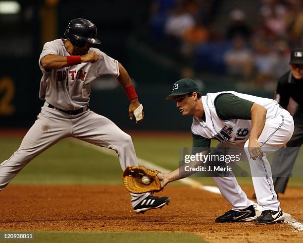Tampa Bay's Travis Lee takes the throw as Boston's Coco Crisp makes it safely back to first during Friday night's action at Tropicana Field in St....