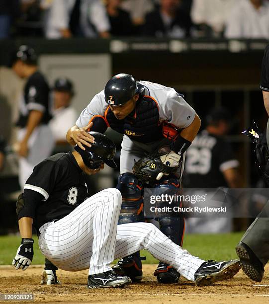 Chicago White Sox' 2nd Baseman, Alex Cintron, is consoled by Pudge Rodriguez after Rodriguez tagged him out at homeplate during the game against the...