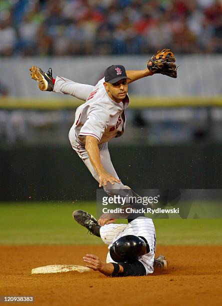 Boston Red Sox 2nd Baseman, Alex Cora, leaps over base runner, Joe Crede, and turns a double play during the game against the Chicago White Sox July...