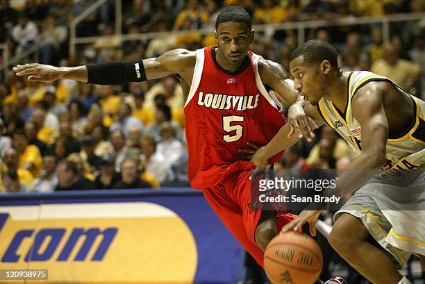 Louisville's Taquan Dean defends at mid court against West Virginia's Darris Nichols during action at the WVU Coliseum in Morgantown, West Virginia...