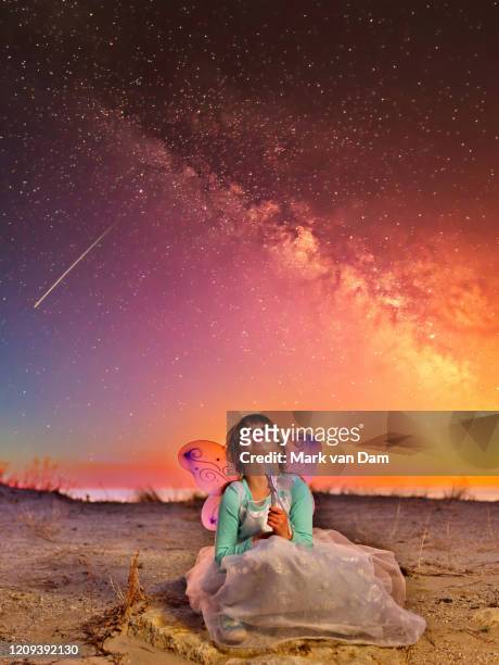 candid portrait of a young girl dressed up as a fairy gazing up towards a star and galaxy filled night sky - fantasy portrait stock pictures, royalty-free photos & images
