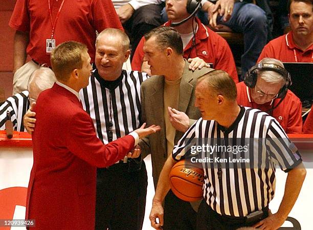 Officials bring the two head coachs together, ray Giacoletti of Utah, left, and Steve Cleveland of BYU, right, after the game started to get very...