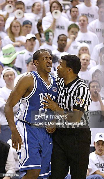 Duke's Chris Duhon gets consolation from a referee after being poked in the eye by a Spartan. Duke won the game 72-50.