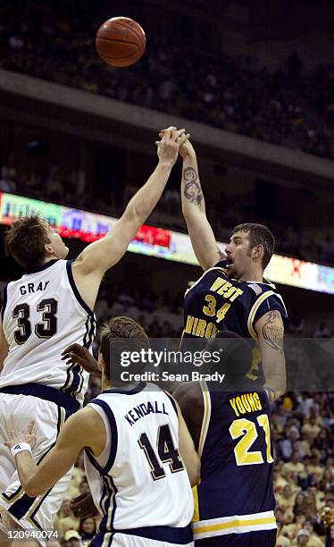 West Virginia's Kevin Pittsnogle has his shot partially blocked by Pittsburgh Panthers Aaron Gray during action at the Petersen Events Center on...