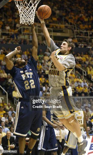 West Virginia's Mike Gansey lays in 2 points over Pittsburgh's Antonio Graves during action at the WVU Coliseum in Morgantown, West Virginia on...