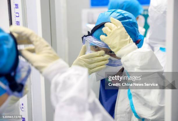 Medical worker adjusts her protective glasses at the Huoshenshan makeshift hospital on February 22, 2020 in Wuhan, Hubei Province of China.