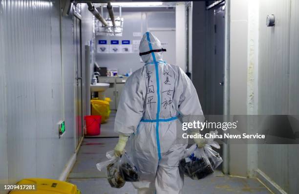 Medical worker carries bags of liquid traditional Chinese medicine at the Huoshenshan makeshift hospital on February 22, 2020 in Wuhan, Hubei...