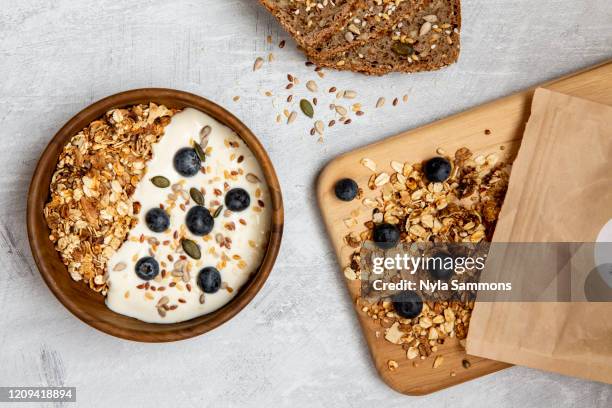 bowl of muesli and blueberries on yogurt, multi-seed bread - bowl of cereal ストックフォトと画像