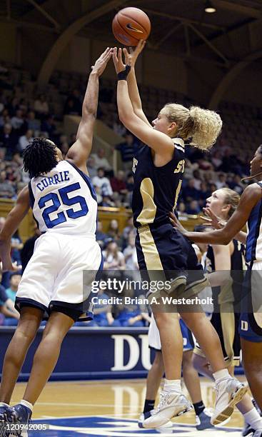 Liz Strunk shoots over the outstretched hand of Monique Currie during first half action, February 12, 2004.